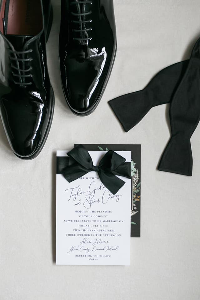 Groom's shoes, groom's bowtie and wedding invitations