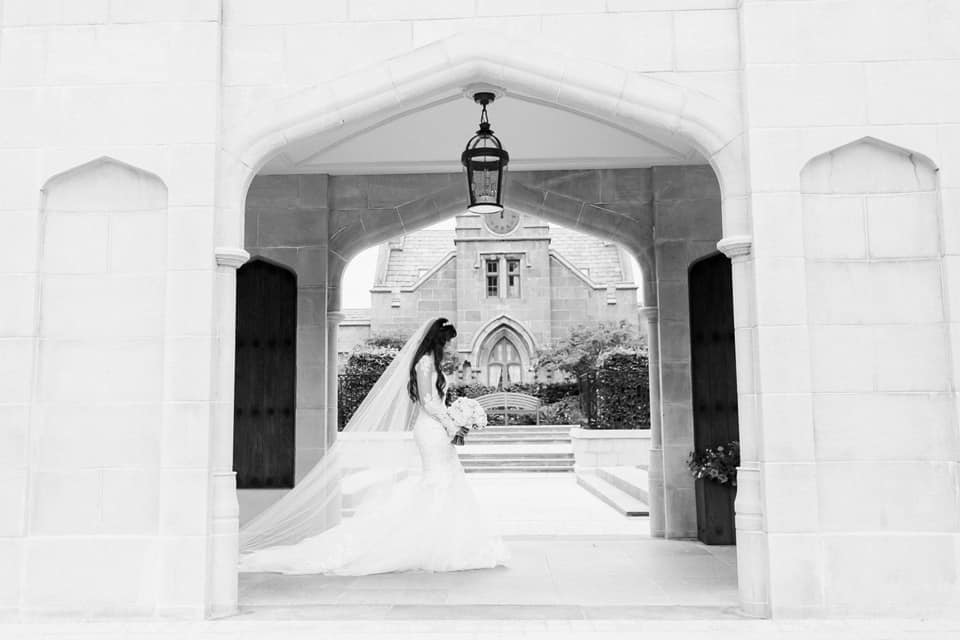 Bride walking under the arch of the Adare Manor