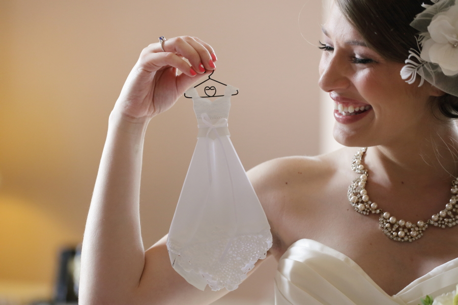 Bride holding a miniature dress