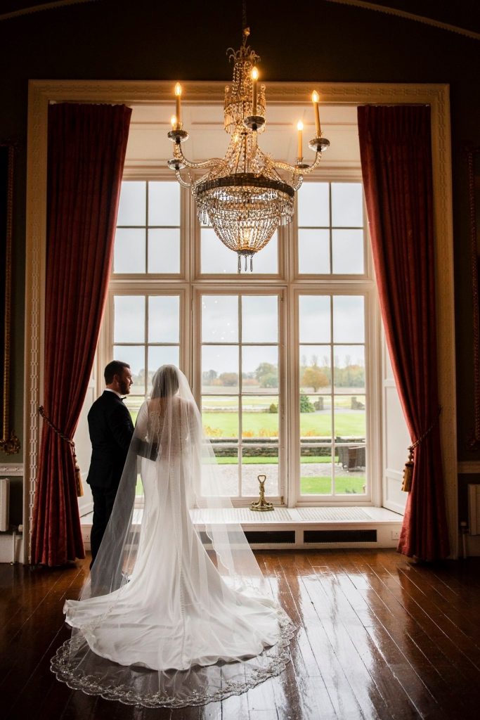 Couple in front of window after first look