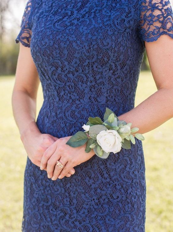 A women wearing a white rose corsage on her wrist.