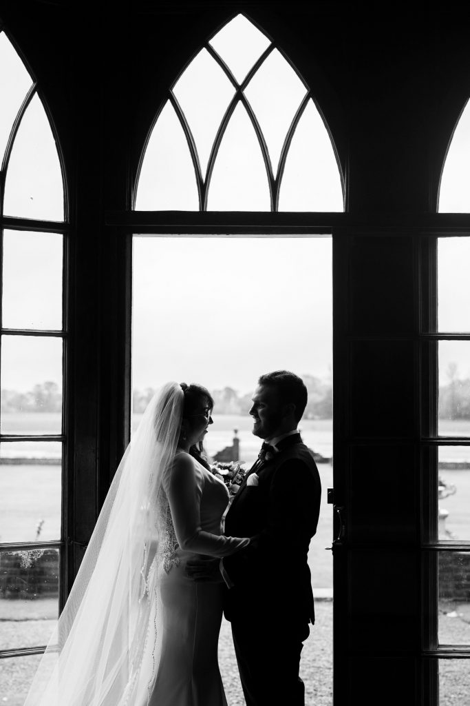 Couple looking at each other in front of window