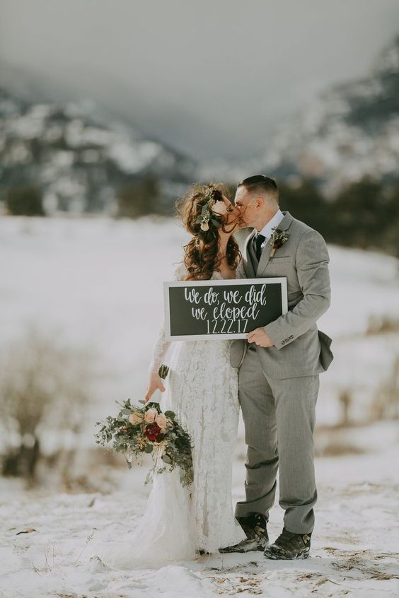 Couple kissing with a sign that says: "We do, we did, we eloped"