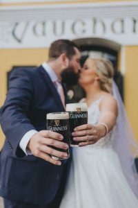 Couple kissing while holding pints of Guinness