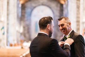 Groom putting on his dad's boutonniere